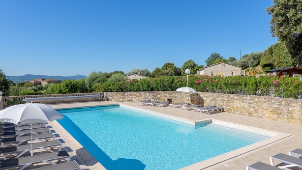 A swimming pool with lounge chairs and umbrellas, surrounded by stone walls and greenery. - Holiday Home “L’Olivier - La Fontinelle” (Bessas)
