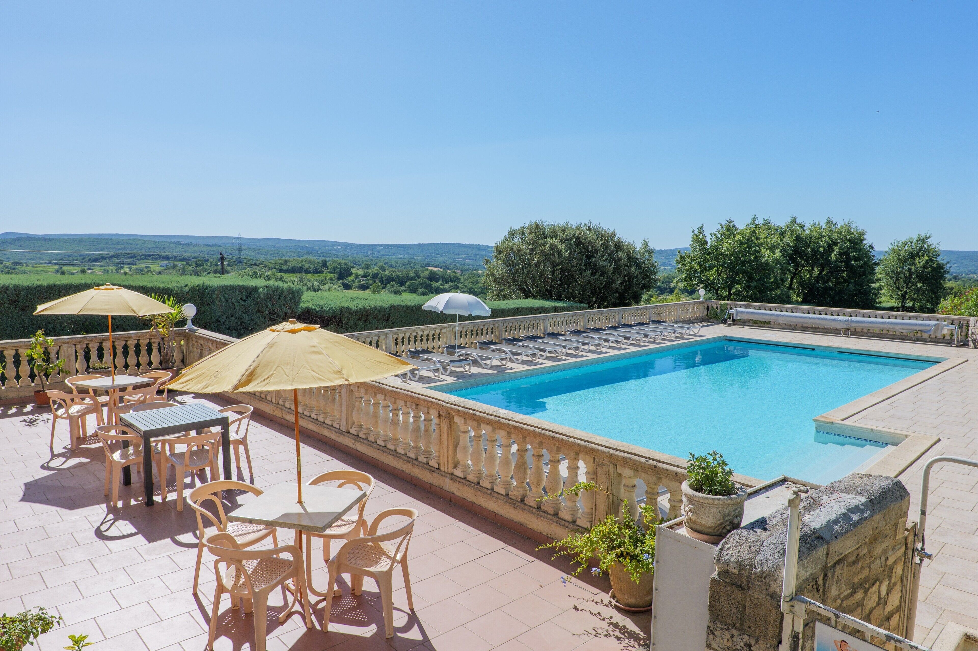Ein Pool auf dem Dach mit freiem Blick auf die Landschaft, Sitzgelegenheiten im Freien und einem Steinbalustraden.