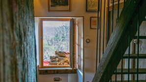 A staircase with a wooden handrail and a window with a view of the outdoors. - Twin houses on the Plateau de Millevaches (Croze)