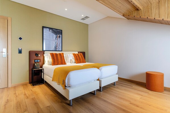 Un dormitorio moderno con cama, mesitas de noche, un teléfono en la pared y un cuadro.