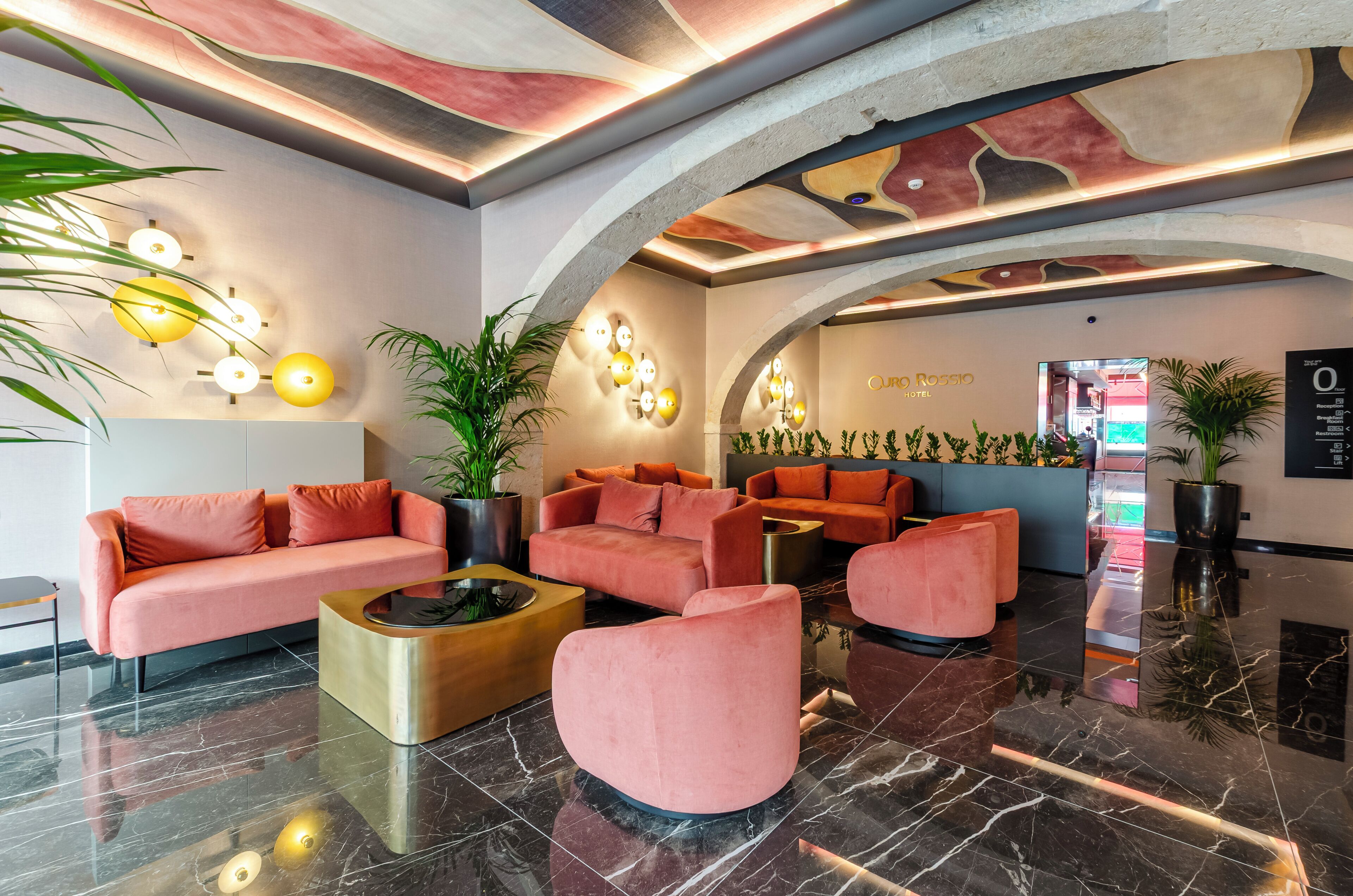 Un hall de hotel con diseño moderno, que incluye sofás, una mesita de centro y una recepción.