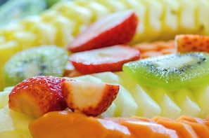 Una variedad de frutas cortadas, como fresas, kiwi y mango.