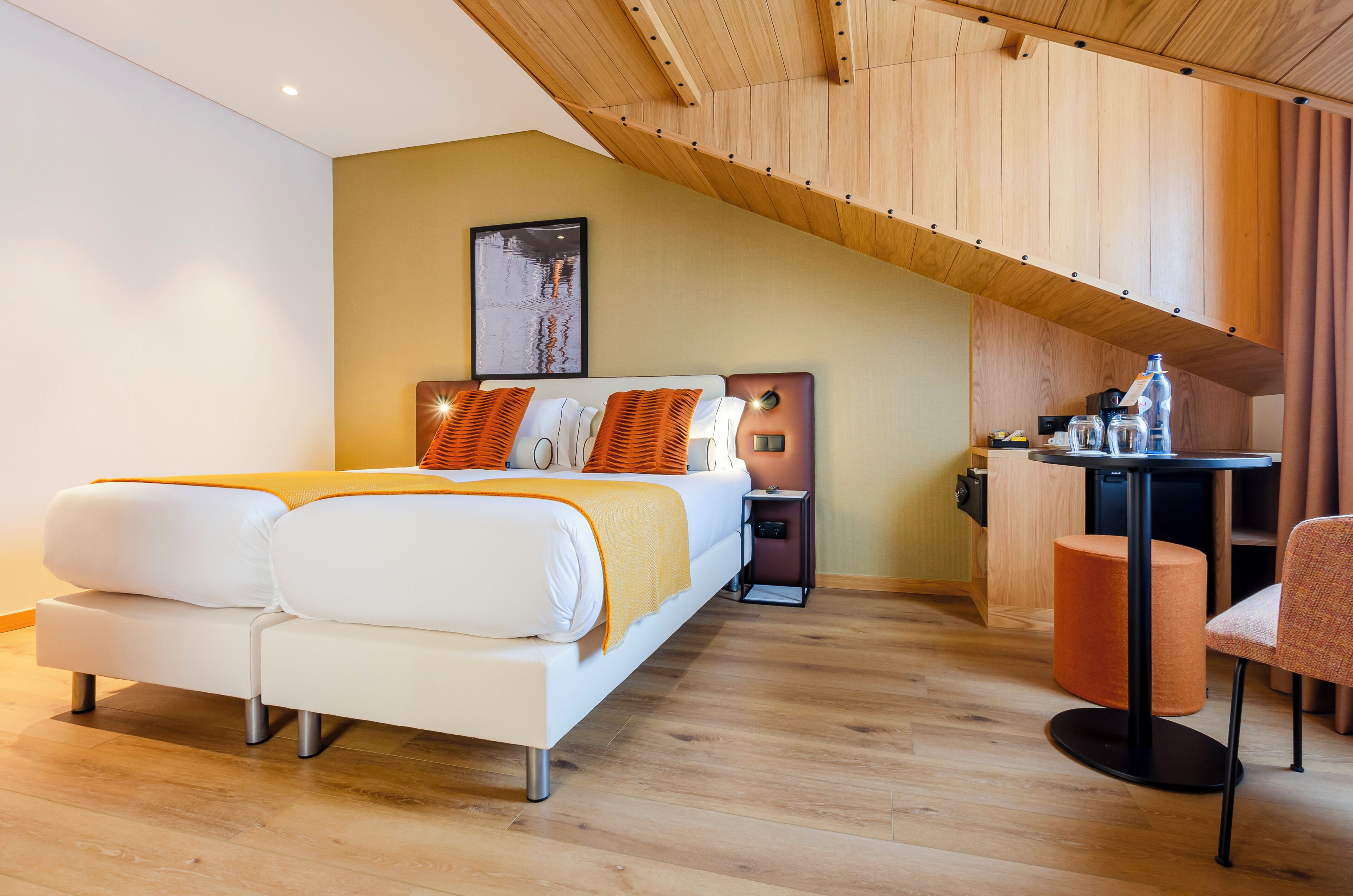 A modern bedroom with a bed, bedside table, and a small desk area.