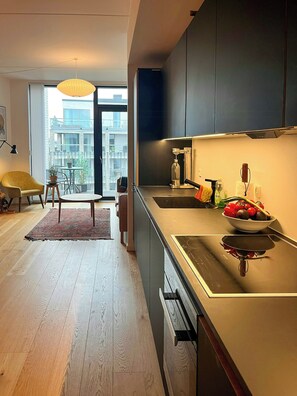 Eine moderne Küche mit großem Fenster, einem Essbereich mit Tisch und Stühlen sowie Blick auf die Stadtlandschaft.
