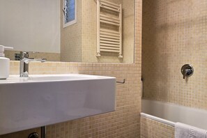 A bathroom with a sink, mirror, towel rack, and a shower area. - Opening Doors Montjuïc-Sants, bright and incredible views (Barcelona)