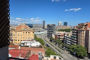 A cityscape with high-rise buildings, a busy road, and a clear sky. - Opening Doors Montjuïc-Sants, bright and incredible views (Barcelona)