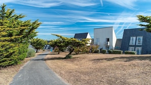 A residential area with modern houses, a paved path, and a clear sky. - Guidel Sea View Apartment for 5 (Guidel)