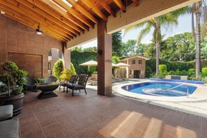 Una piscina al aire libre, sombrillas, tumbonas
