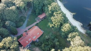 Vista aérea de una propiedad con un edificio de techo rojo, un sendero y un lago.