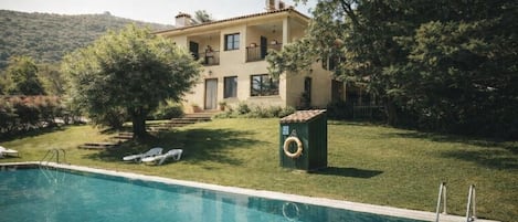 Una piscina al aire libre de temporada, sombrillas