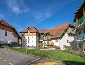 A row of traditional chalet-style buildings with wooden facades and pitched roofs, arranged in a courtyard. - Studio for 2 Near Lake Annecy (Giez)