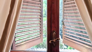 Ein Fenster mit Holzklappläden und einem Messing-Türgriff.