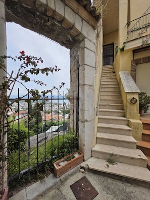 A staircase leading to a balcony with a view of a cityscape.