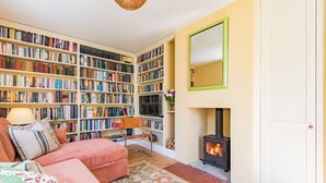 Ein gemütliches Wohnzimmer mit Kamin, Bücherregal und einer bequemen Sitzecke.