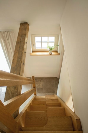 Eine Holztreppe mit einem Fenster darüber.