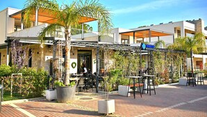 Een restaurant met terras, een overdekte patio en uitzicht op de architectuur van het gebouw.