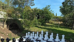 Ein Schachspiel draußen vor einer Baumlandschaft und blauem Himmel.