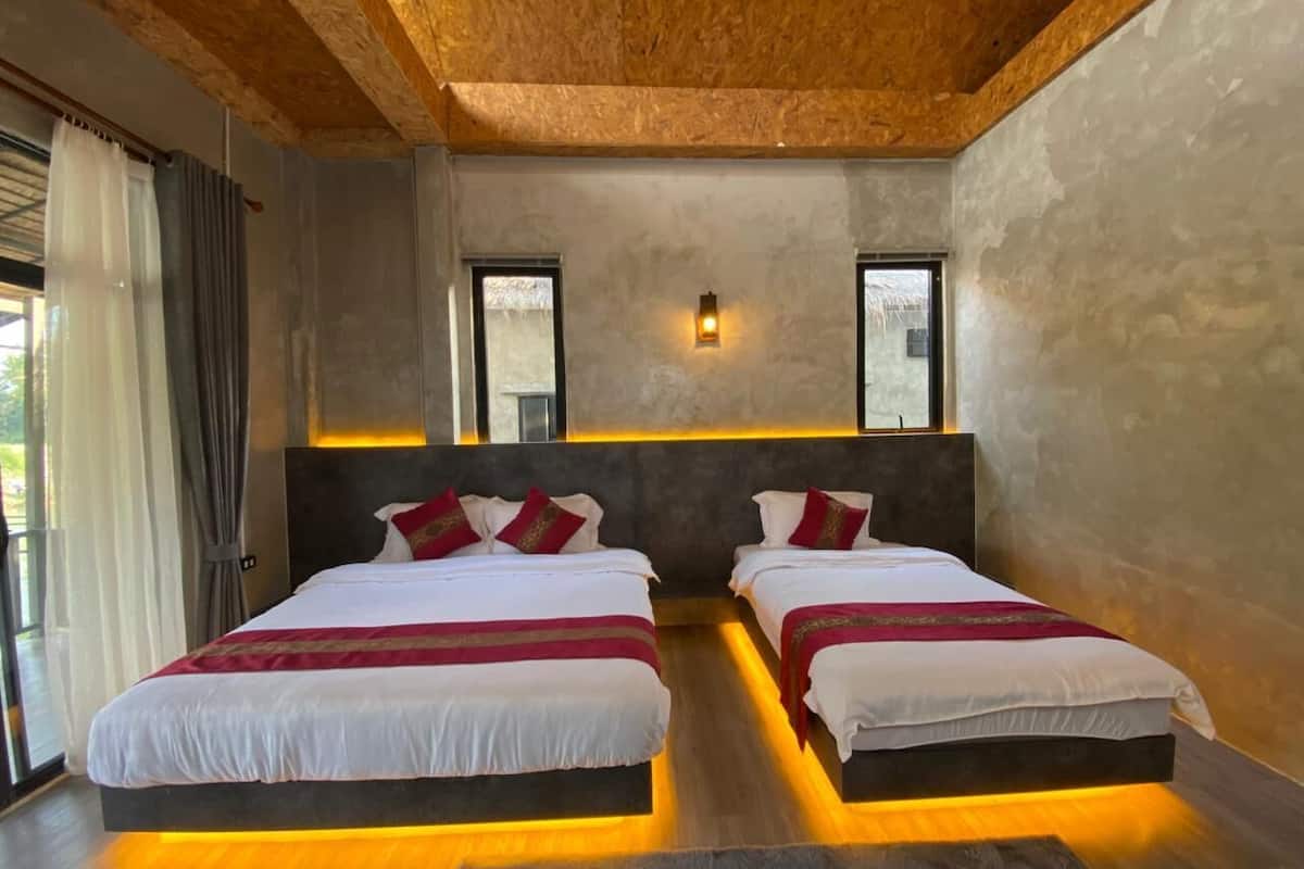 Un dormitorio moderno con dos camas, techo de madera y un ventanal grande.