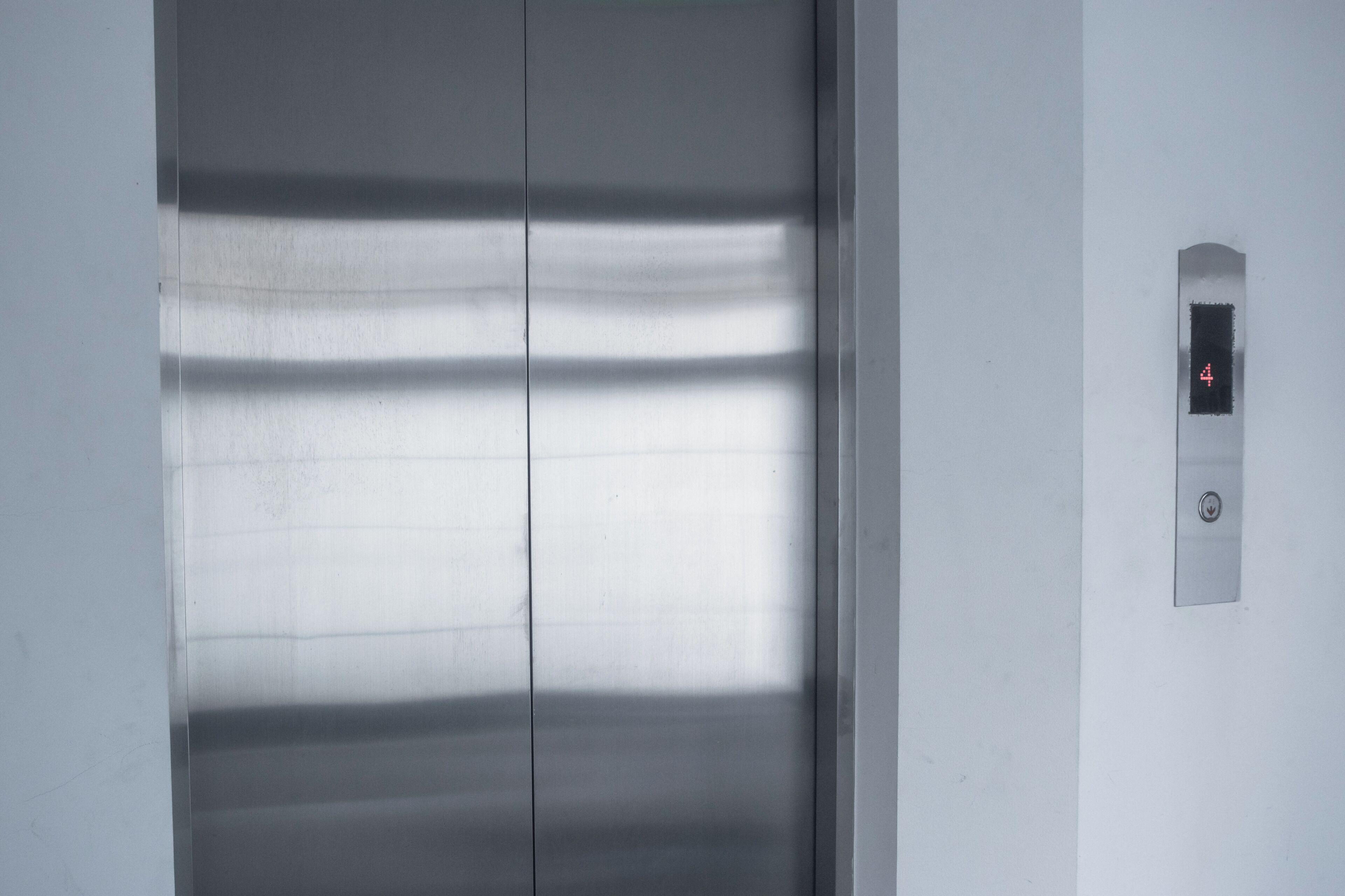 Eine Metall-Aufzugstür mit einer digitalen Anzeige, die die Zahl 4 zeigt.