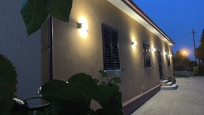 A building exterior with exterior lighting, a concrete pathway, and a small garden area. - 🦋the village villa 🦋 (Santa Caterina dello Ionio)