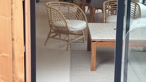 Eine moderne Küche mit Essbereich, ausgestattet mit einem Holztisch und Korbstühlen.