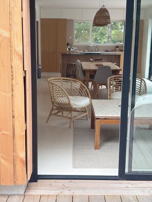 A modern kitchen with a dining area, featuring a wooden table and wicker chairs. - Maison familiale à l'Ile Tudy - At the end of the street, it's the sea! (Île-Tudy)