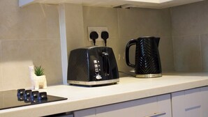Un comptoir de cuisine avec un grille-pain, une machine à café et une petite plante en pot.
