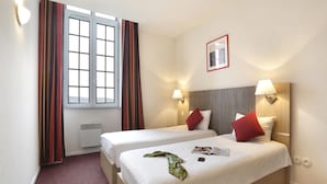 A hotel room with two beds, a window with curtains, a framed picture on the wall, and bedside lamps. - Elegant Vineyard Stay for Three (Epernay)