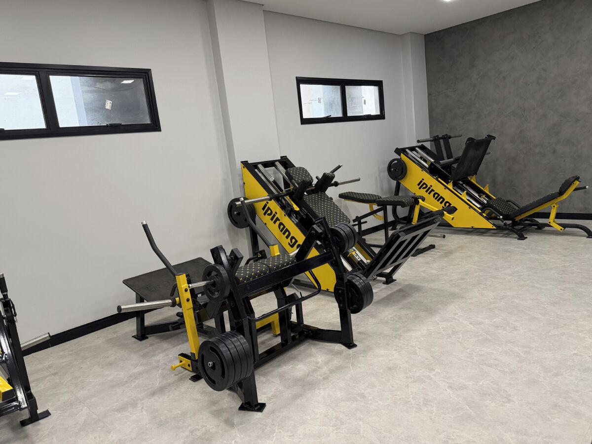 A gym with exercise equipment, including a bench press and a leg press machine.