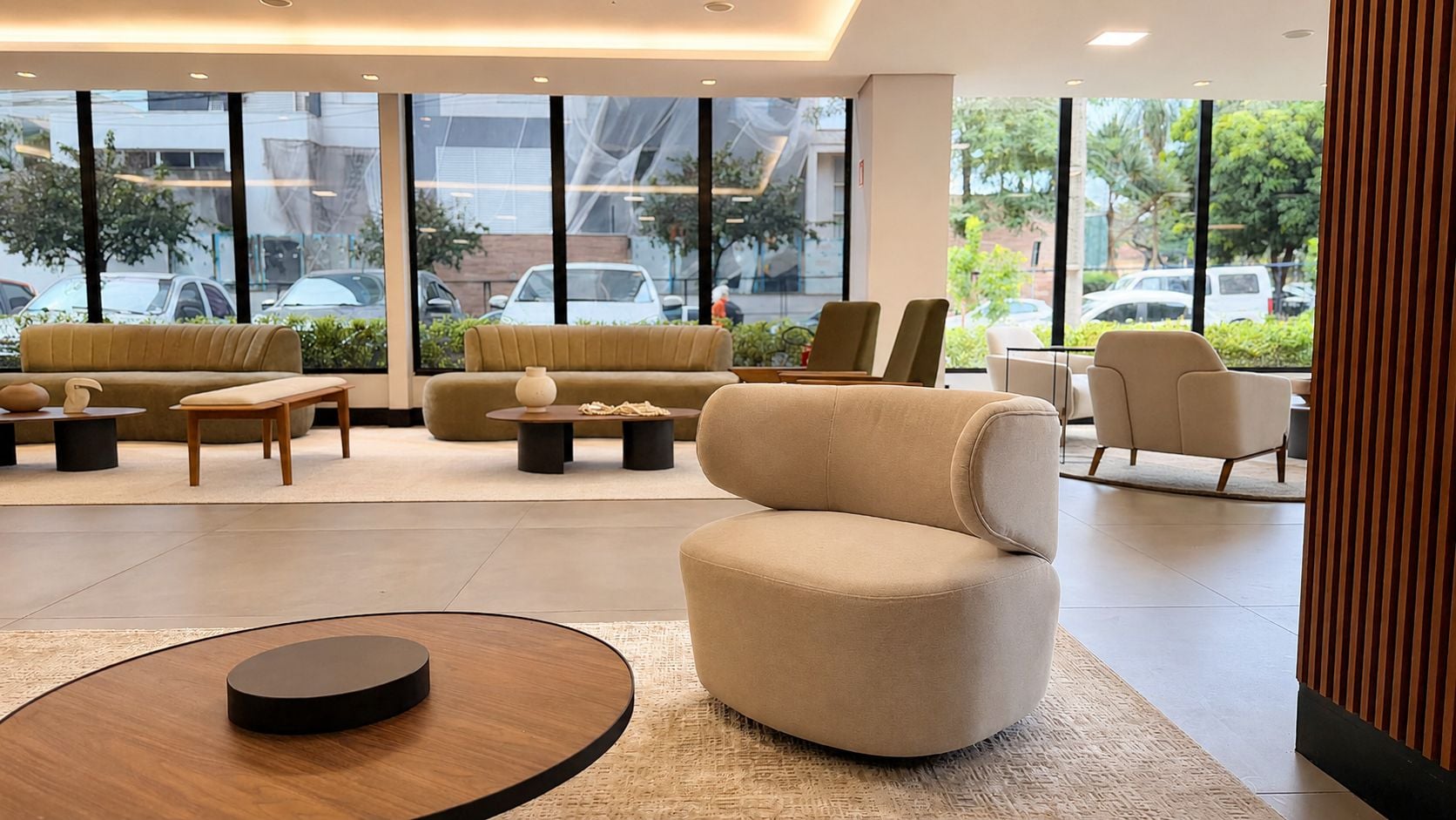 Um saguão moderno de hotel com um sofá, poltronas e uma mesa de centro.