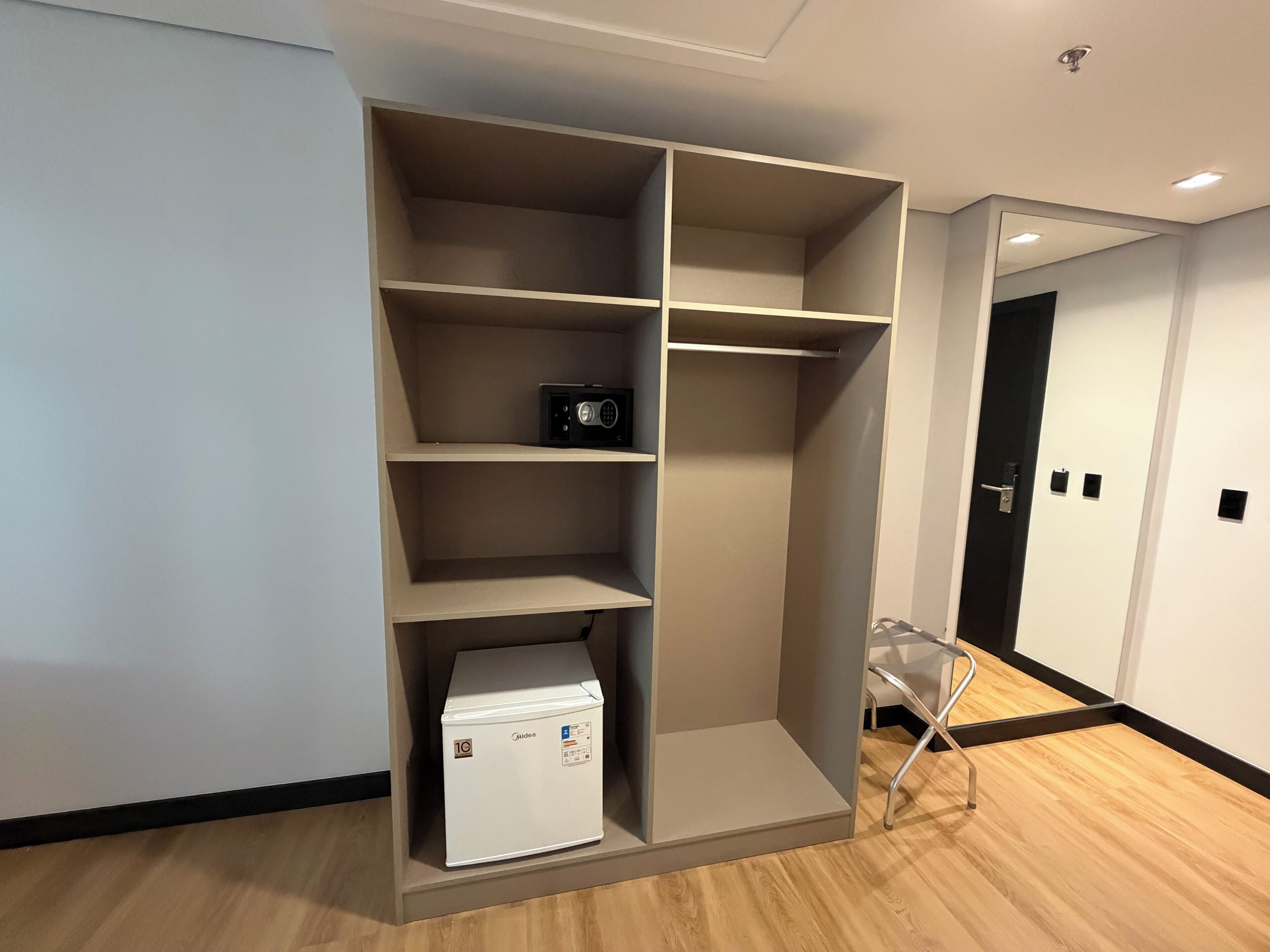 A modern room with a built-in wardrobe, a small appliance, and a clear chair.