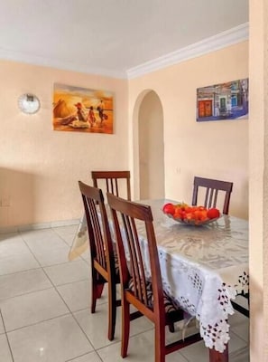 A dining area with a table, chairs, and a fruit bowl. - Apartment in Playa de las Americas - Swimming pool, garden and excellent location (Arona)