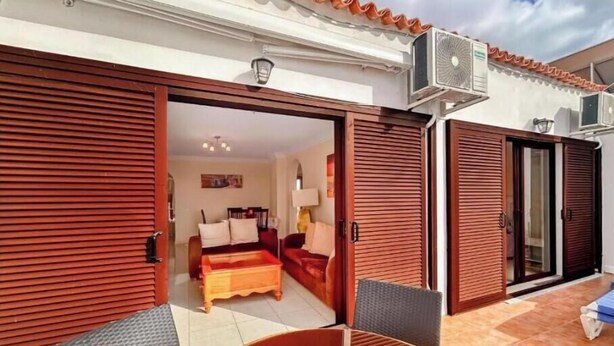 A room with a bed, a sofa, and a dining table with chairs. - Apartment in Playa de las Americas - Swimming pool, garden and excellent location (Arona)
