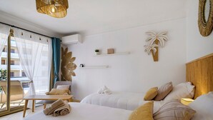 Ein Hotelzimmer mit zwei Betten, einem Balkon mit Stuhl und Wanddekorationen.