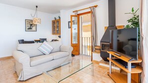 Una sala de estar con sofá, televisión y chimenea.