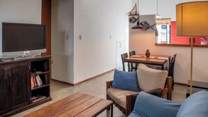 A living room with a TV, wooden furniture, a dining area with chairs and a table, and a lamp. - House in Pocitos, near the stadium and the promenade (Montevideo)