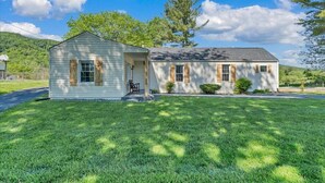 A two-story house with a front porch, a small attached garage, and a well-maintained lawn.