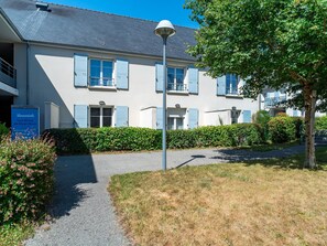 A building with a grey roof, blue shutters, and a sign indicating it is a vacation rental. - Art Village Apartment for Four (Pont-Aven)