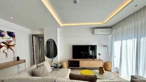 A modern living room with a sofa, TV, and decorative items. - Alimos Escape 3 (Alimos)