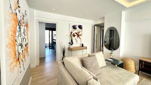 A modern living room with a sofa, a coffee table, and a painting on the wall. - Alimos Escape 3 (Alimos)
