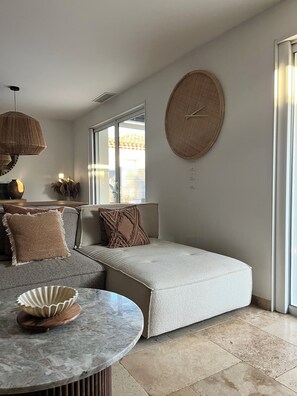Ein modernes Wohnzimmer mit einer Couch, einem runden Tisch und einem großen Fenster.