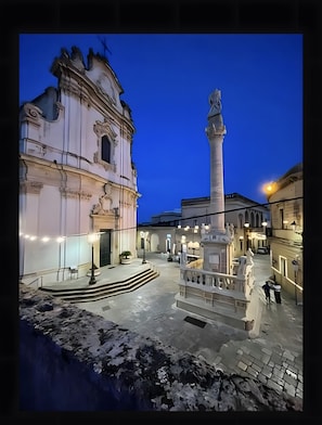 A historic building with a central monument, a staircase, and a paved courtyard. - Room 'Casa Sant'Anna 1' with Air Conditioning (Presicce)
