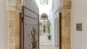A narrow alleyway with a gated entrance, potted plants, and stone walls. - Room 'Casa Sant'Anna 2' with Air Conditioning (Presicce)