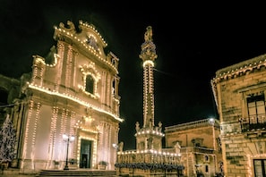 A historic building with ornate architecture, a prominent tower, and a well-lit facade. - Room 'Casa Sant'Anna 2' with Air Conditioning (Presicce)