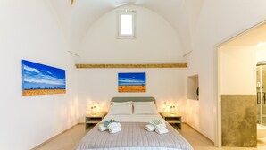 A bedroom with a bed, two bedside tables, a window, and two paintings on the wall. - Room 'Casa Sant'Anna 2' with Air Conditioning (Presicce)