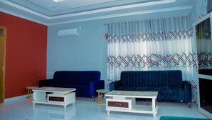 A living room with two sofas, a coffee table, and a TV. - Kinindo Light Hotel (Bujumbura)