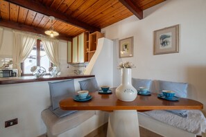 Un coin repas avec une table en bois, des bols bleus et un vase blanc.