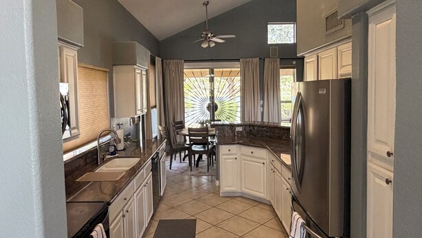 A kitchen with a refrigerator, cabinets, a dining area, and a ceiling fan. - Luxury Lakefront Retreat Fire Pit, Mountain Views & Resort Amenities (Goodyear)