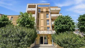 A multi-story residential building with a central entrance, surrounded by greenery. - Charming Studio - Sleeps 2 - bright (Grasse)