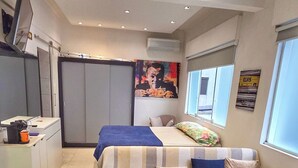 A modern room with a bed, a sofa, a desk, and a window. - Studio Pé na Areia - Channel 4 (Santos)